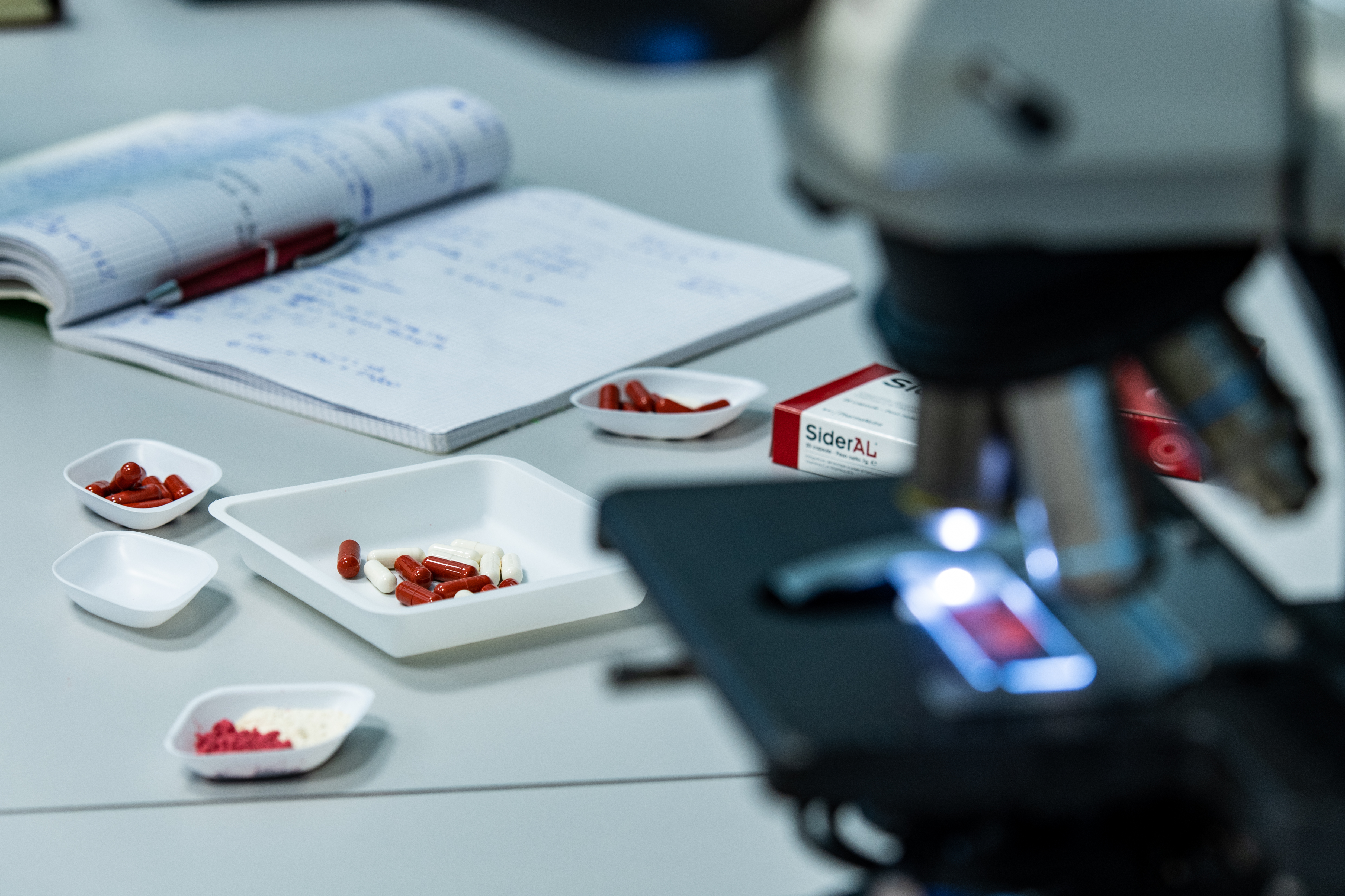 laboratorio di ricerca scientifica pharmanutra - immagine con microscopio e capsule di sideral forte