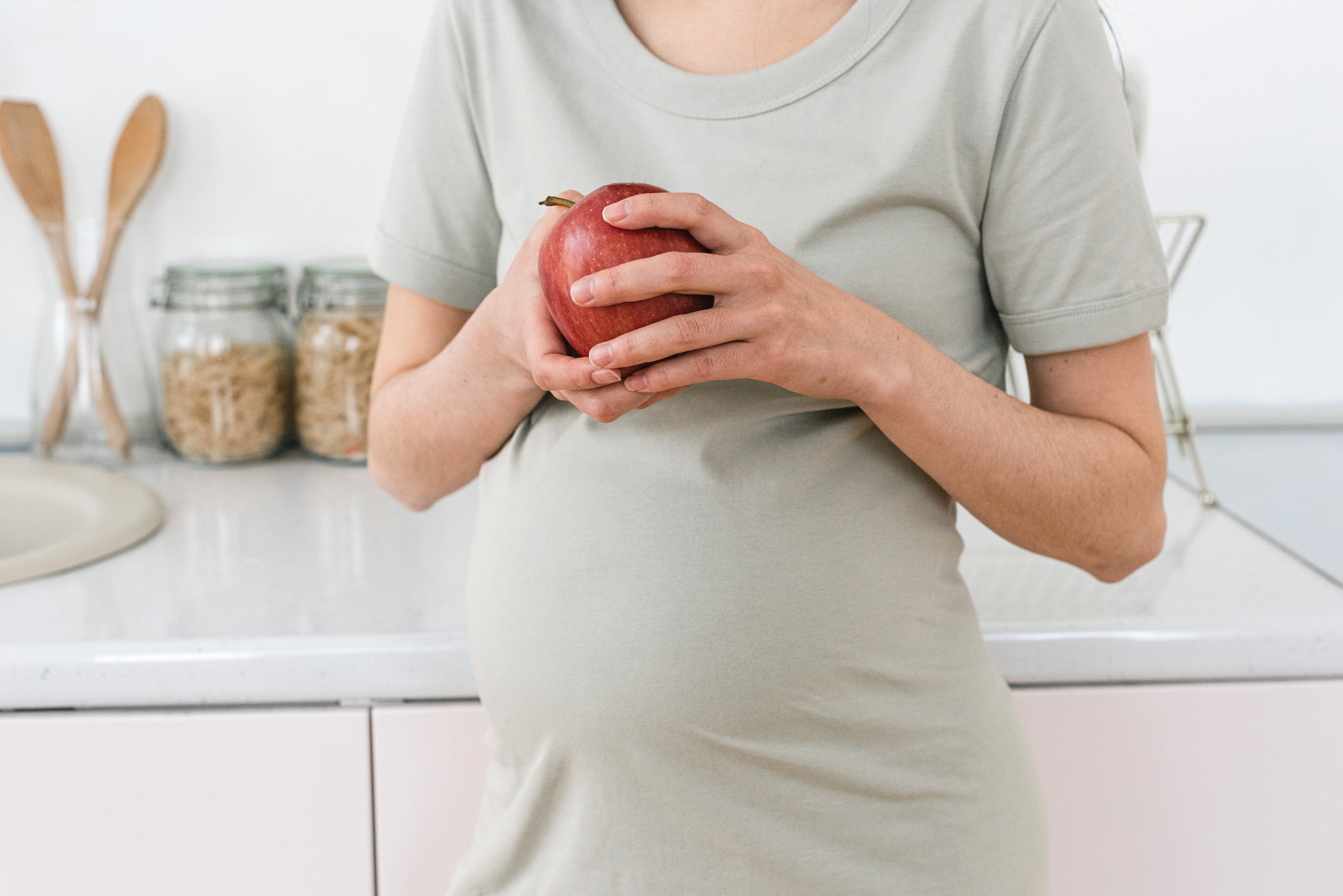 integratori e gravidanza - cosa mangiare quando si aspetta un bambino - donna incinta con una mela in mano