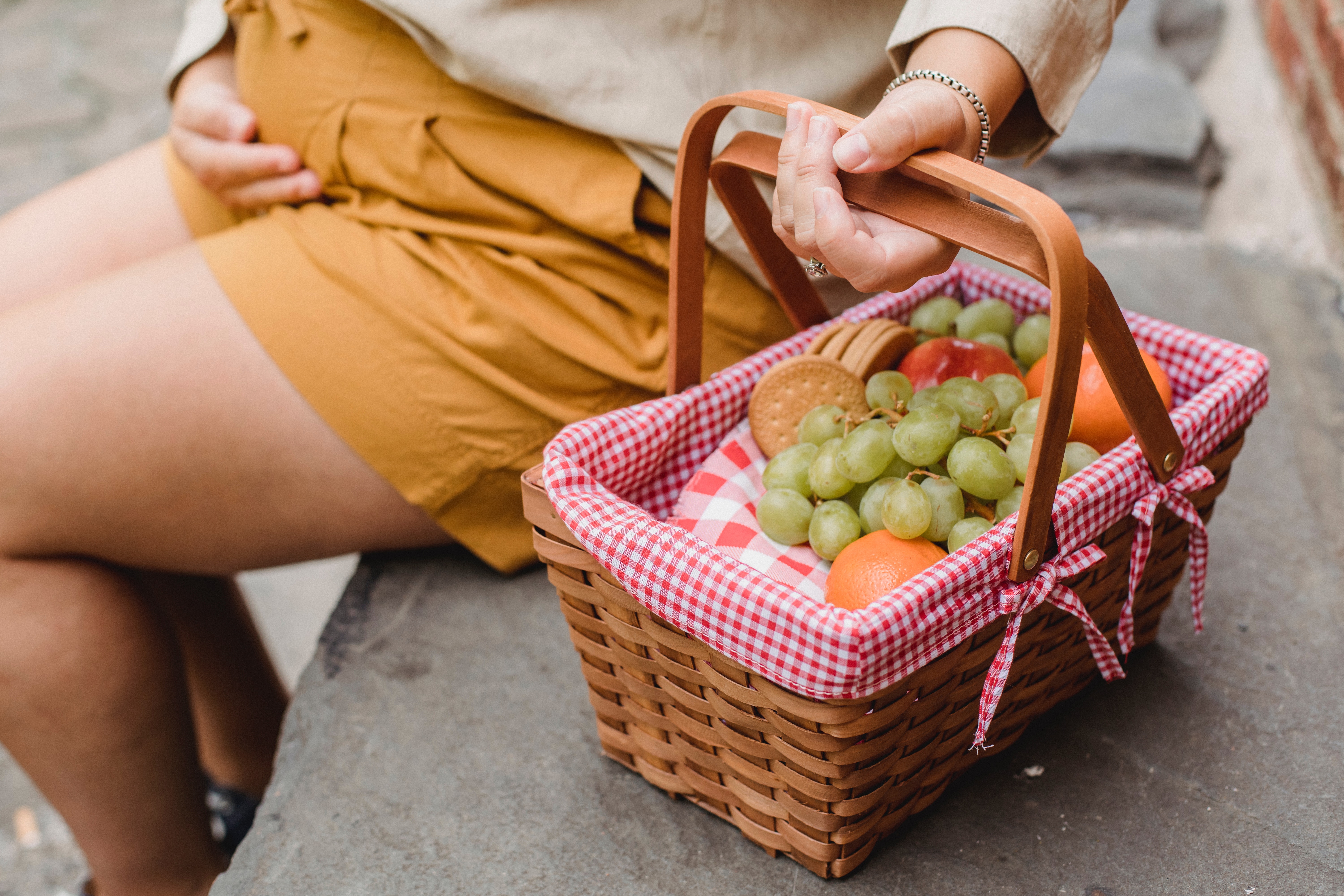 consigli su cosa mangiare in gravidaza - donna incinta con cestino di frutta in mano