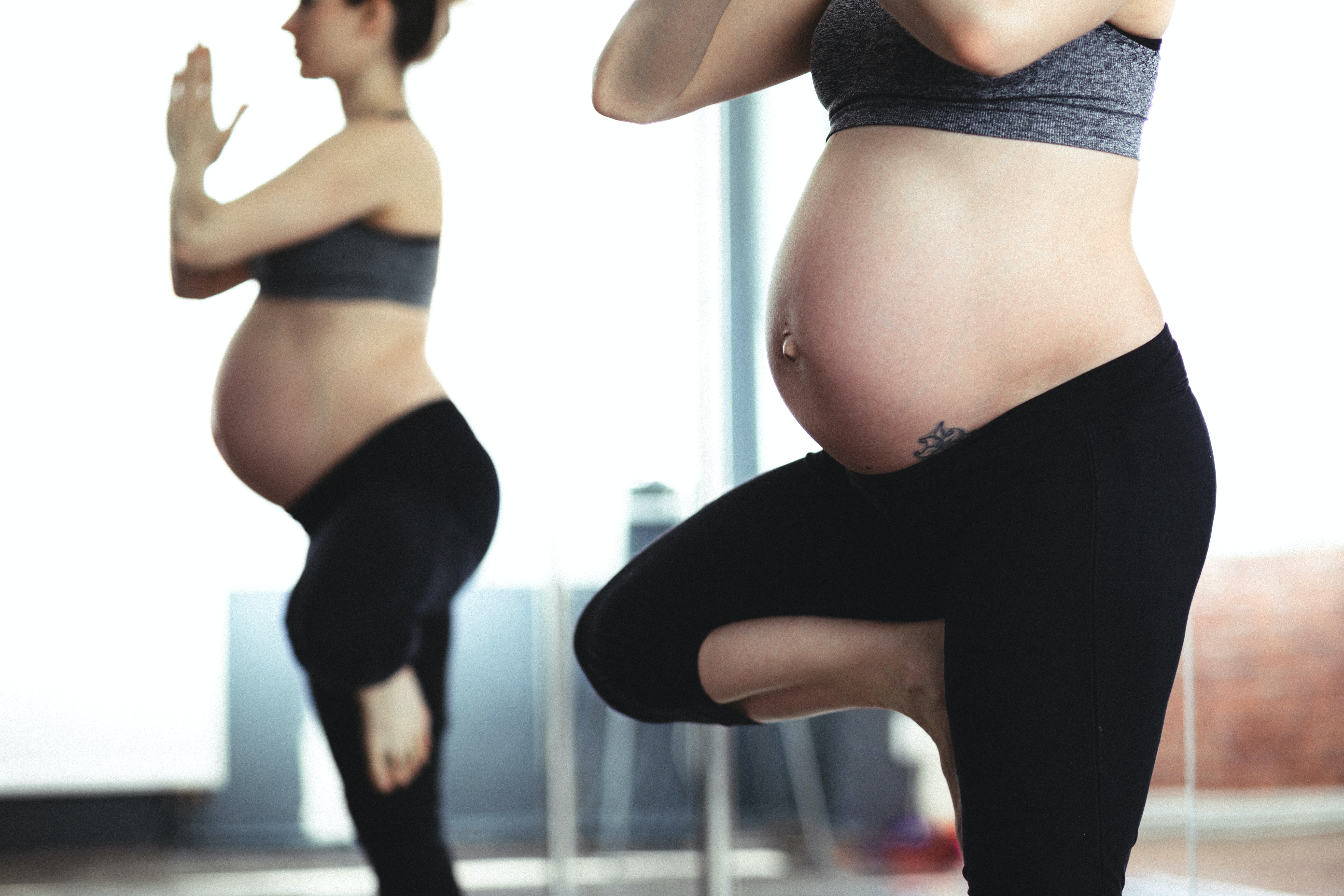 mantenersi in salute durante la gravidanza - donna incinta in piedi che fa yoga